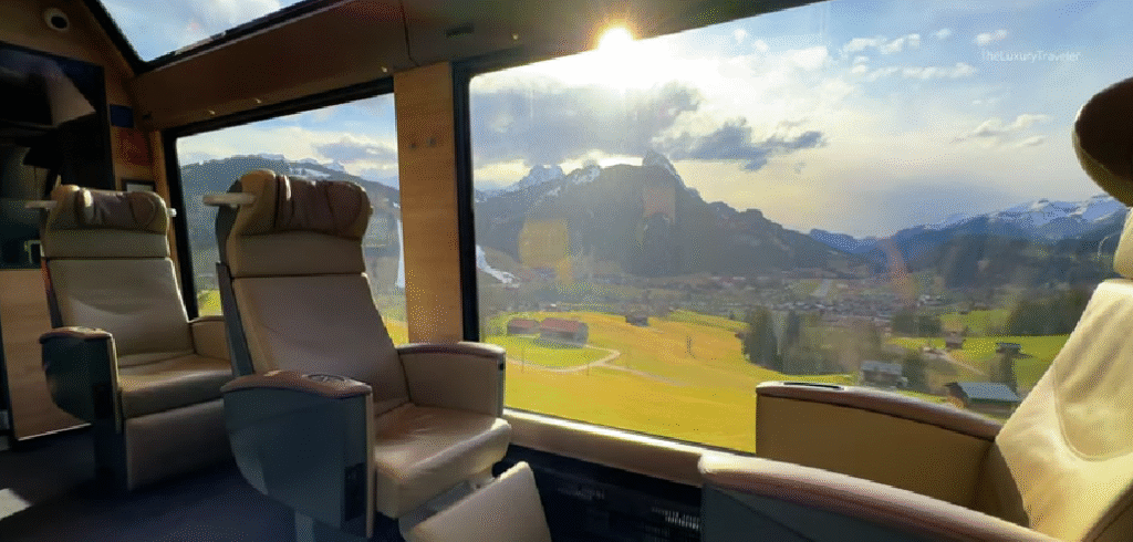 GoldenPass Line train traveling through rolling green hills, traditional Swiss chalets, and sparkling lakes.