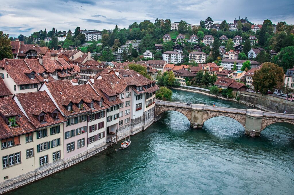 Bern with its medieval sandstone buildings, the iconic Zytglogge clock tower, and the Aare River flowing nearby.