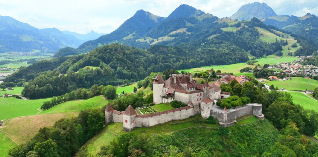 Gruyères Castle, seen from above, surrounded by green hills, as part of Switzerland itinerary 5 Days with Swiss Travel Pass.